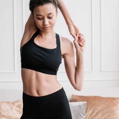 A person stretching their leg in a calm, focused manner.