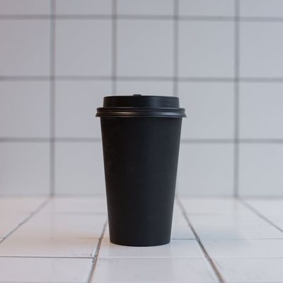 Close-up of a simple dumbbell on a dark floor.